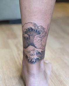 a person with a tattoo on their leg that has a wave coming out of it