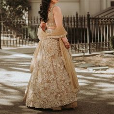 a woman in a wedding dress standing on the street