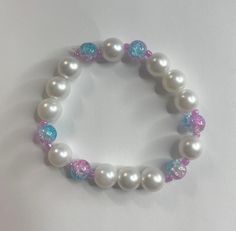 Faux pearl bracelet made of large faux pearls, pink and blue crackle glass beads, stretchy elastic, and pink seed beads. Faux Pearl Bracelet, Crackle Glass, Pearl Bracelet, Bracelet Making, Elk, Faux Pearl, Seed Beads, Glass Beads, Jewelry Bracelets