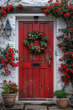 a red door is surrounded by flowers and potted plants