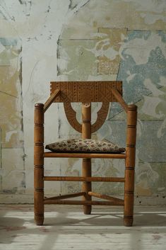 a wooden chair sitting in front of a wall