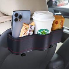 there is a cup holder in the back seat of a car with coffee and snacks