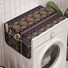 a white washer sitting next to a dryer in a room with tiled walls