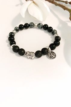 One of my best selling Bracelets with a cute antique silver elephant and OM charm.  This beautiful bracelet was designed to support those of us that tend to take on the emotional energy of others.  Snowflake  Obsidian Well-known in the crystal world as a powerful protection stone,  obsidian crystals help clear away negative energy from your psyche. Well-known as powerful Empath protection from psychic attacks and clearing of psychic smog, helping you to ground your root chakra.  Instead of hidin Bohemian Black Crystal Bracelet With 8mm Beads, Black Bohemian Bracelet For Healing, Black Bohemian Bracelets For Healing, Bohemian Black Charm Bracelet As Gift, Bohemian Black Healing Bracelet, Bohemian Black Charm Bracelet Gift, Bohemian Black Adjustable Charm Bracelet, Adjustable Black Bohemian Charm Bracelet, Adjustable Black Holistic Bracelets