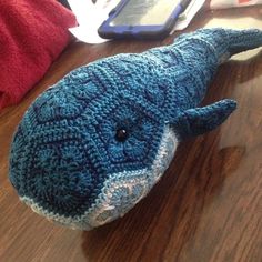 a crocheted stuffed animal laying on top of a wooden table