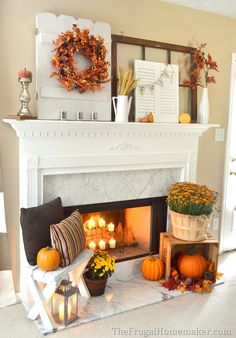 a living room with a fire place filled with pumpkins and other fall decorations on the mantle