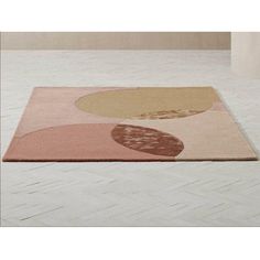 a rug with an abstract design on it in the middle of a white tiled floor