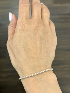 This beautiful delicate diamond tennis bracelet weights 2.50 ct and showcases 70 round diamonds. The diamonds boast a color of G/H and S12/I1 in color. A great bracelet if you are starting your jewelry collection. Dazzling Ethical Diamond Round Bracelet, White Round Cut Diamond Bracelet, White Diamond Tennis Bracelet With Diamond Accents, Diamond Tennis Bracelet With Jubilee Style, Dazzling Diamond White Round Tennis Bracelet, Dazzling Diamond White Tennis Bracelet, White Diamond Bracelet With Single Cut Diamonds, White Round Tennis Bracelet With Prong Setting, White Diamond Bracelet With Accents