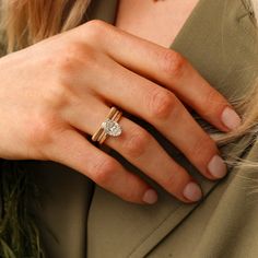 a close up of a person wearing a ring with a diamond on the middle finger