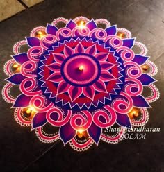 an intricate design on the ground with candles lit up for diwaling and decorating