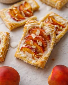 peach danish with white icing and almonds on top, sitting next to sliced peaches