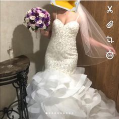 a woman in a wedding dress holding a bridal bouquet and wearing a yellow hat