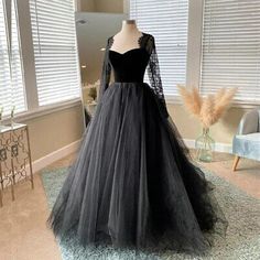 a black dress is on display in a room with blue carpet and white walls,