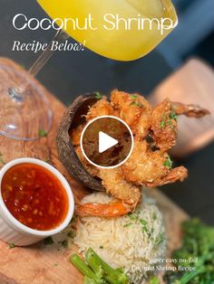 a plate with shrimp, rice and sauce on it next to a glass of wine