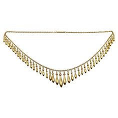 This 14k gold fringe necklace encapsulates the essence of romantic jewelry from the Victorian era. Graduated elongated drops topped with round spheres dangle from the 15” necklace. The gorgeous surface of the gold is what is known as a bloom finish--a technique used in the Victorian era to dip gold jewelry into acid to burn off all other metals near the gold’s surface. While this necklace is 14k gold, the outside layer is closer to 20k and gives off the warm buttery glow of a high karat gold. What we love about fringe necklaces is their lovely movement that catches the light so beautifully. The necklace measures 15”, and the drops range in size from 7/8” to 1/2”. The piece weighs 20.5 grams. It is in near perfect condition, with a barrel clasp at the top. Unmarked but acid tests as 14k gol Gold Fringe Necklace, Chanel Flower, Crescent Moon Necklace Gold, Gold Moon Necklace, Gold Fringe, Vintage Beads Necklace, Romantic Jewellery, Gold Cross Necklace, Gold Bead Necklace