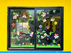 the window is decorated with colorful flowers and birdhouses in it's reflection,