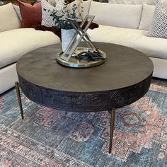 a living room with couches, tables and rugs on the carpeted floor