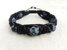 "The protection bracelet made of beads Snowflake obsidian (12mm, 10mm) , braided with three cords of different texture (satin cord, waxed cord and leather cord). Obsidian is lustrous volcanic glass; molten lava that cooled so quickly it had no time to crystallize. Obsidian has no boundaries or limitations, as a result works extremely fast and with great power. Obsidian is a strongly protective stone, forming a shield against negativity, provides a grounding cord from the base chakra to the cente Hand Wrapped Black Jewelry With Waxed Cord, Black Bohemian Braided Bracelets Hand Wrapped, Casual Black Hand Wrapped Bracelets, Casual Black Hand-wrapped Bracelets, Handmade Black Bracelets With Waxed Cord, Black Adjustable Braided Bracelets With Round Beads, Bohemian Black Leather Bracelet With Round Beads, Black Bohemian Leather Bracelet With Round Beads, Adjustable Black Braided Bracelet With Round Beads