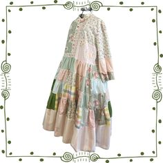 "This one of a kind, handmade, cottagecore dress is a boho coquette dream! It is a patchwork dress in pioneer, prairie dress style in summery cotton with a very full skirt, tiers and ruffles. Accented with floral appliques *Cool, lightweight cotton coquette style *Mismatched button front *Mismatched sleeves with contrasting interior look great rolled up *2 pockets *Upcycled boho patchwork  *Extremely flowy & twirly! *Whimsical cotton florals *Many, many details including mismatched roll up cuffs Patchwork Quilt Dress, Cottagecore Prairie Dress For Garden Party, Cottagecore Cotton Dress With Lace Patchwork, Bohemian Cotton Vintage Dress For Garden Party, Bohemian Floral Patchwork Dress For Garden Party, Spring Bohemian Boho Dress With Patchwork, Bohemian Prairie Dress With Ruffles For Garden Party, Green Patchwork Dress For Garden Party, Cottagecore Cotton Dress With Floral Patchwork