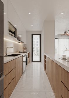 a long kitchen with white counter tops and wooden cabinets, along with an open door leading to the outside