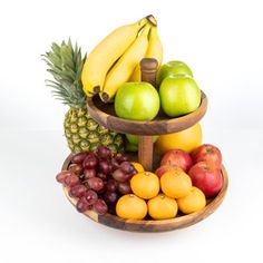 three tiered fruit tray with bananas, apples, oranges and grapes