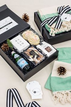 two black boxes filled with different types of food and drinks on top of a table