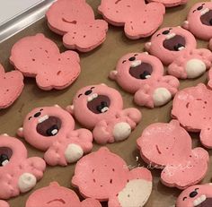 there are many cookies shaped like teddy bears on the table with pink frosting and white icing