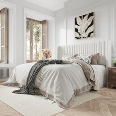 a bedroom with white walls and wooden floors