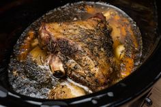 a close up of a cooked chicken in a crock pot with broth and spices