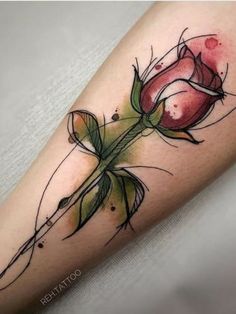 a rose tattoo on the leg with watercolors and ink in it's center