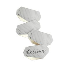 three white marble coasters with the word atlanta written on them in black ink and gold foil