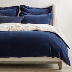 a bed with blue sheets and pillows on it