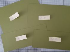 three pieces of green paper with white stickers on them and one has a date