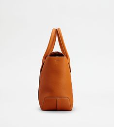 Central ribbing and tubular handles characterize this elegant shopping bag with Tod's logo stamped on the front. Crafted in soft calfskin leather, it features an internal pouch and an adjustable, removable shoulder strap. To accompany everyday outfits with class and femininity. Modern Tan Bag With Top Carry Handle, Cognac Calf Leather Shoulder Bag With Top Carry Handle, Calf Leather Top Handle Bag For Shopping, Calf Leather Bags With Top Handle For Shopping, Pebbled Leather Top Handle Satchel For Shopping, Pebbled Leather Shoulder Bag With Detachable Handle For Shopping, Top Handle Pebbled Leather Satchel For Shopping, Calf Leather Tote Bag With Detachable Handle, Cognac Calf Leather Tote Bag