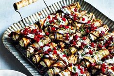 a platter filled with food on top of a metal tray next to a plate