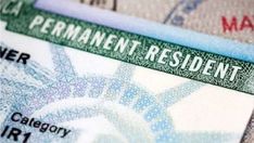 a green and white id card with the word permanent resident on it's side