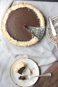 a chocolate pie on a plate with a slice missing