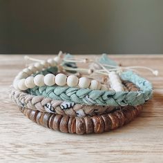 three different bracelets on top of a wooden table