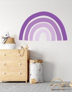 a child's room with a wall decal that has a rainbow painted on it