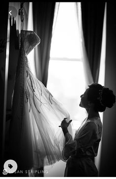 a woman is standing in front of a dress