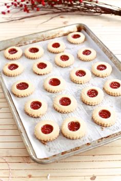 cookies with strawberry jam in the middle on a baking sheet, ready to be baked