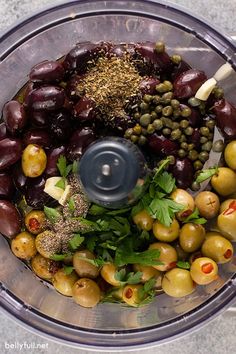 an overhead view of olives, capers and other ingredients in a food processor