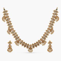 Product Description A blend of modern luxury and elegance. This antique necklace set will make all your special occasions a little more special. Our designers at Tarinika crafted this beautiful minimal looking temple necklace to meet your everyday needs. It features Goddess Lakshmi and floral motifs, studded with high quality CZ stones and gold beads droplets. A tasteful and elegant necklace that goes well with all Indian attire. Details & Specifications: Materials used: CZ stones with Antiq Antique Necklace Set, Gold Earrings For Kids, Temple Necklace, Gold Bridal Jewellery Sets, Buy Jewellery Online, Jewelry Sale, Goddess Lakshmi, Elegant Necklace, Gold Necklace Designs