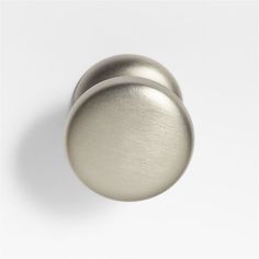 two metal knobs on a white surface, one is shiny and the other is plain