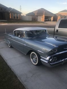 an old car is parked in front of a house