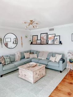 a living room with blue couches and pictures on the wall above it's coffee table