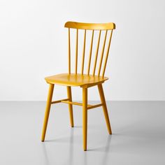 a yellow chair sitting on top of a white floor