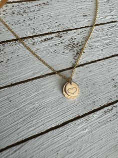 The sweetest necklace ever….featuring a hand stamped heart set on a larger stamped disc and a dainty chain, this little beauty goes with everything! Material is 14k gold filled. Chain measures 16” Handmade at the time you order. Personalized Round Pendant Heart Necklace For Everyday, Dainty Hand Stamped Charm Necklace For Anniversary, Dainty Hand-stamped Charm Necklace For Anniversary, Anniversary Dainty Hand-stamped Charm Necklace, Meaningful Heart-shaped Everyday Jewelry, Meaningful Everyday Heart Jewelry, Dainty Hand Stamped Charm Necklaces For Everyday, Dainty Hand Stamped Charm Necklace For Everyday, Dainty Hand Stamped Jewelry For Everyday