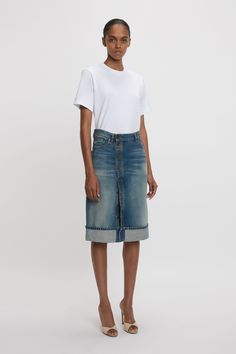 A contemporary twist on the traditional denim skirt, the Placket Detail Denim Skirt reflects the house’s elevated approach to reimaging luxury denim for the modern consumer. Defined by a distinctive asymmetric front placket closure with antique copper branded denim shank buttons and folded hem detail, it embodies sophisticated sexiness. Tobacco topstitching and a branded leather patch at the back of the waist complete the look. Styled with the Victoria T-Shirt and High Heel  Victoria Beckham Pla Vintage Indigo, Shank Button, Denim Details, Leather Patches, Antique Copper, Victoria Beckham, Denim Skirt, High Heel, The Modern