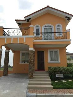 an orange house with white windows and balconies